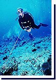 Diver using the reef hook at Blue Corner